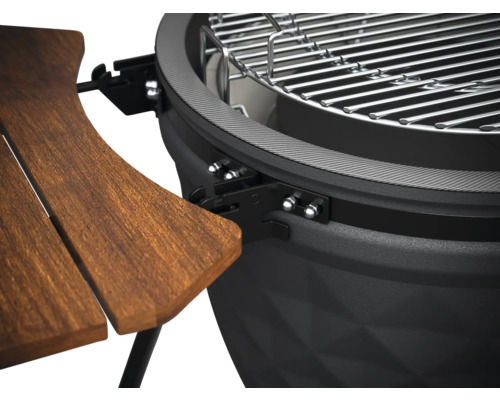 Detailansicht eines Kugelgrills mit Holztisch