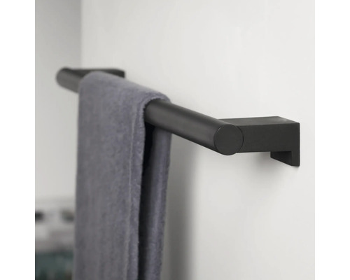 Schwarzer Handtuchhalter mit Handtuch an einer Wand