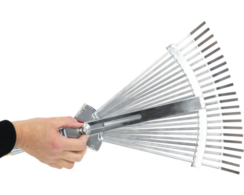 Une main ajuste un balai à gazon réglable.