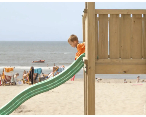 Enfant sur un toboggan dans une aire de jeux de plage