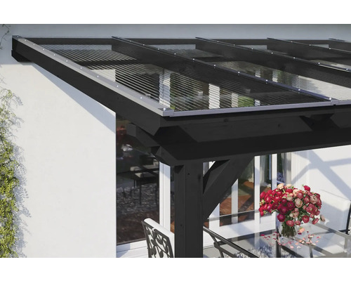 Toit de terrasse avec toit transparent et cadre en bois noir sur une maison d''habitation