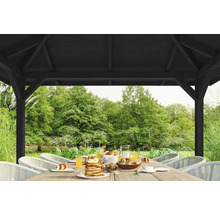 Scène de jardin sous une pergola en bois avec une table dressée et vue sur le jardin