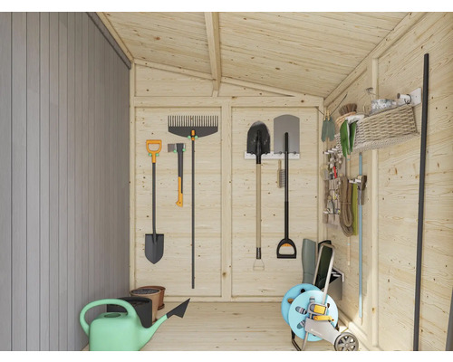 Vue intérieure d''une cabane de jardin avec divers outils de jardinage tels que des pelles, des râteaux, un arrosoir et un dévidoir.