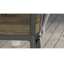 Detailansicht eines Hochbeets mit Holzverkleidung und einer Person, die einen Drehknopf an der Seite bedient