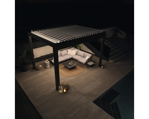 Pergola mit Lamellendach und Lounge-Möbeln auf Terrasse bei Nacht