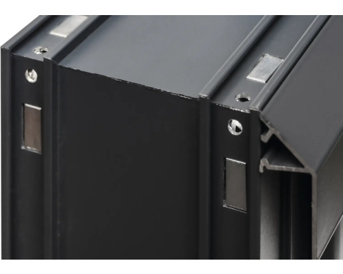 Detailansicht eines schwarzen Aluminiumprofils mit Magneten und Schraubenlöchern.