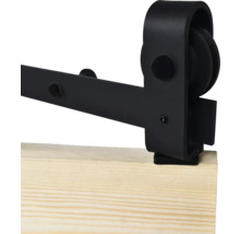 Détail d'une quincaillerie de porte coulissante noire sur une planche en bois.
