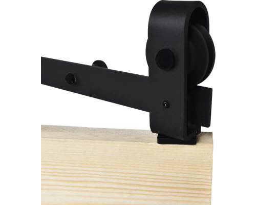 Détail d'une quincaillerie de porte coulissante noire sur une planche en bois.