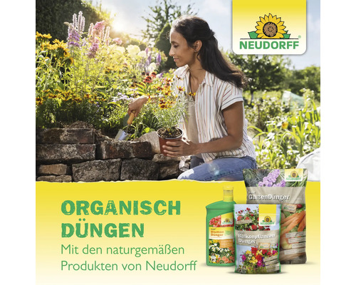 Frau pflanzt Blumen mit Neudorff Produkten im Garten.
