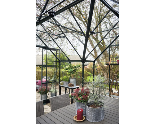 Serre avec plantes, table et chaises dans le jardin