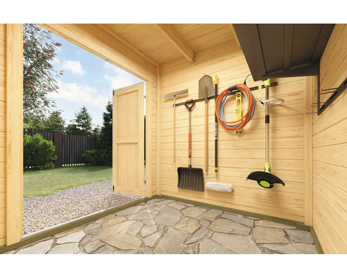 Vue intérieure d''un abri de jardin avec outils et matériel de jardinage au mur.