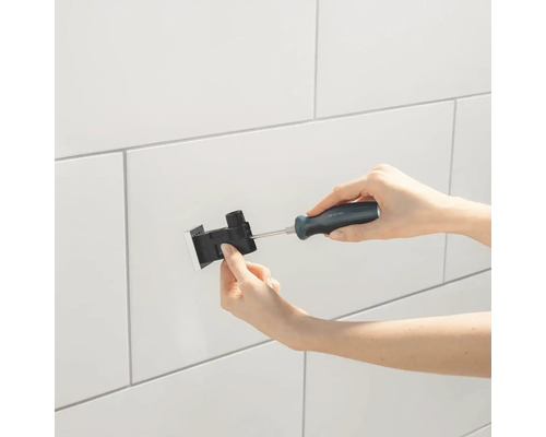 Installation d''un robinet avec un tournevis sur un mur.