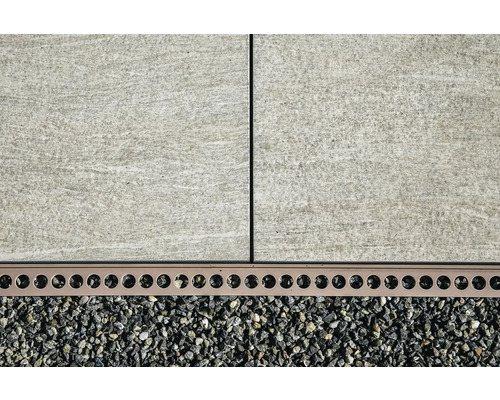 Nahaufnahme von Terrassenplatten, Entwässerungsrinne und Kies