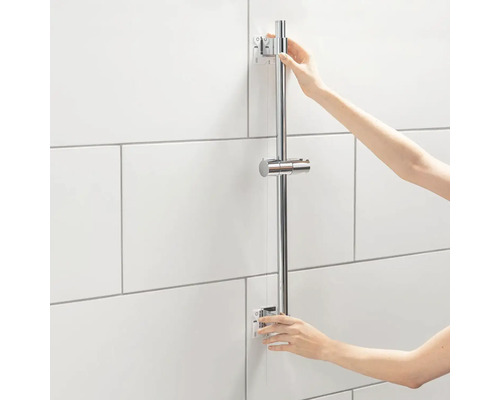 Personne installant une barre de douche dans la salle de bains