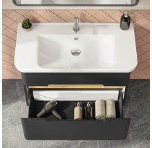 Badezimmerwaschtisch mit Waschbecken, Armatur, Ablage und offenem Schubfach für Badutensilien wie Handtücher und Föhn.