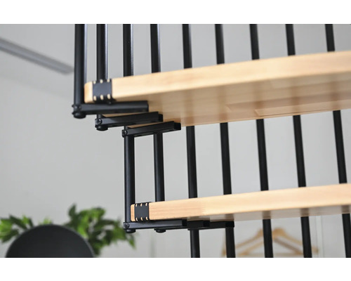 Detailansicht einer Wendeltreppe mit Holzstufen und schwarzem Metallgeländer