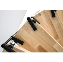 Detailansicht einer Raumspartreppe mit Holzstufen und schwarzen Metallelementen