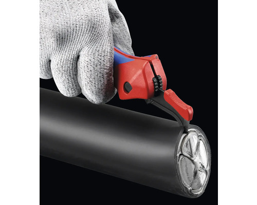 Eine Hand mit Schutzhandschuh schneidet ein Kabel mit einem Kabelentmanteler.