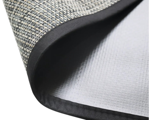 Detailaufnahme einer Tischmatte mit gewebter Oberfläche und schwarzem Rand