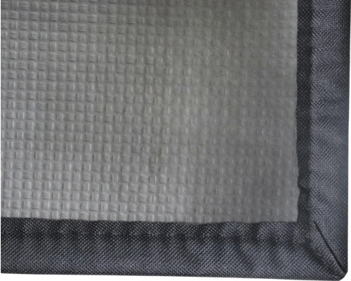 Detailansicht eines Textils mit strukturierter Oberfläche und eingefasstem Rand