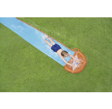 Draufsicht eines Kindes, das auf einer Wasserrutsche im Garten liegt