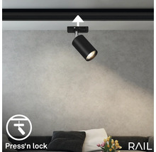 Schwarzer Schienenstrahler an einer Schiene mit ''Press''n lock'' Symbol