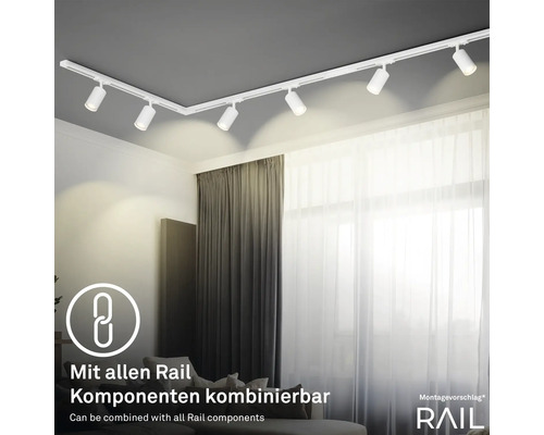 Deckenleuchte mit Spots und Schienensystem in einem Wohnzimmer.