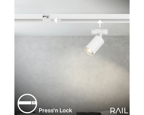 Innenaufnahme einer Decke mit einem weißen Schienensystem und einem einzelnen Strahler, der Licht abgibt