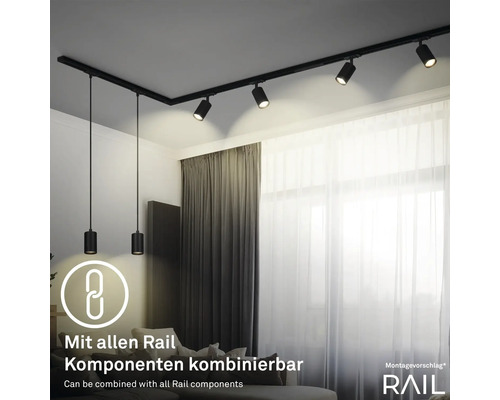 Raum mit schwarzem Schienensystem mit Strahlern und Pendelleuchten an der Decke