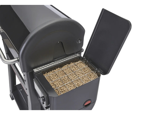 Vue détaillée d''un gril à pellets avec réservoir à pellets ouvert, rempli de pellets de gril.