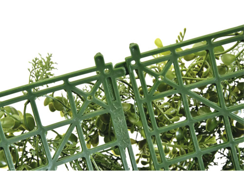 Gros plan d''une grille en plastique avec mécanisme de fixation et plantes décoratives vertes.