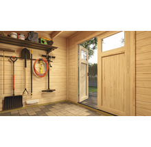 Vue intérieure d'un abri de jardin avec porte en bois ouverte et outils de jardinage au mur