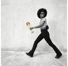 Frau geht mit einer Tischleuchte.