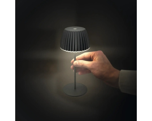 Schwarze LED-Tischleuchte mit Hand im Bild