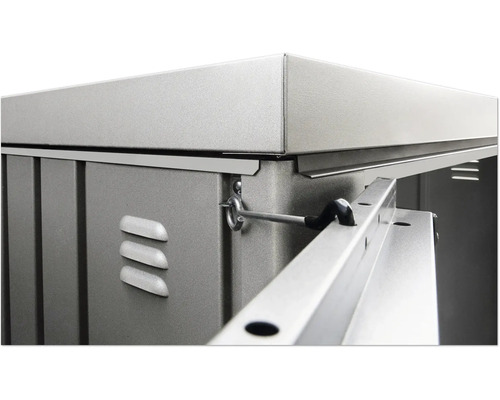 Vue détaillée d''un abri de jardin avec des éléments métalliques, des fentes d''aération et un mécanisme de verrouillage.