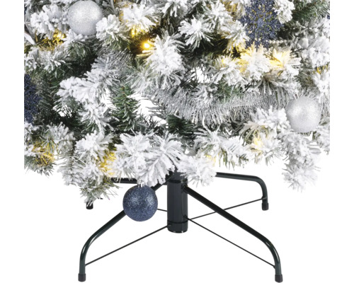 Gros plan sur un sapin de Noël artificiel enneigé avec décorations