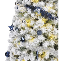 Gros plan d''un sapin de Noël enneigé avec des boules de Noël et une guirlande
