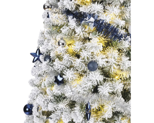 Gros plan d''un sapin de Noël enneigé avec des boules de Noël et une guirlande