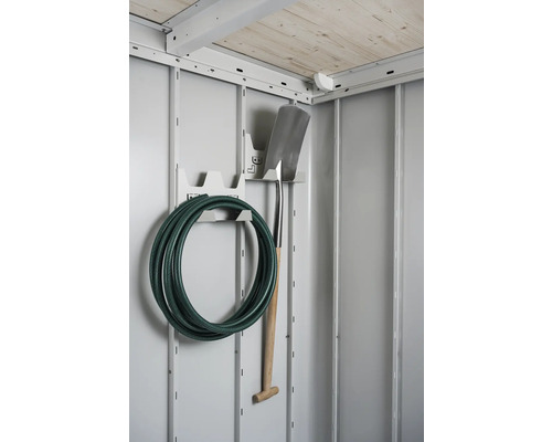 Gartenschlauch und Spaten hängen an einer Halterung in einem Gerätehaus.