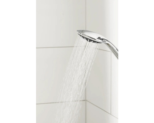 Pomme de douche chromée avec eau courante sur fond de carrelage blanc