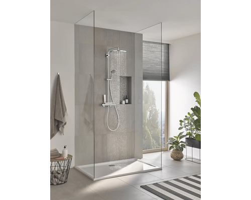 Douche à l''italienne avec receveur, robinetterie et paroi en verre dans une salle de bains au design moderne.
