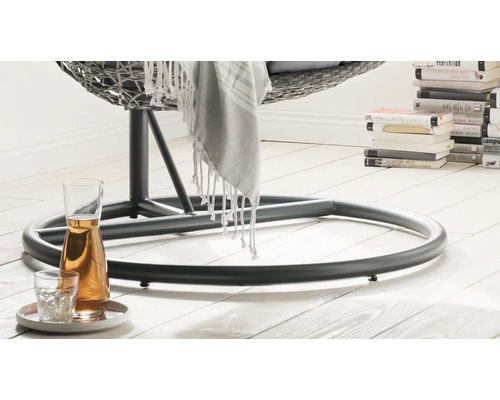 Gros plan du pied d''un fauteuil suspendu en rotin avec carafe à boisson et verre