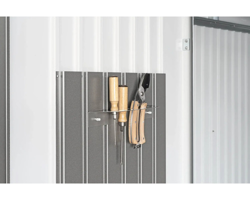 Outils sur un mur métallique avec des tournevis et un sécateur