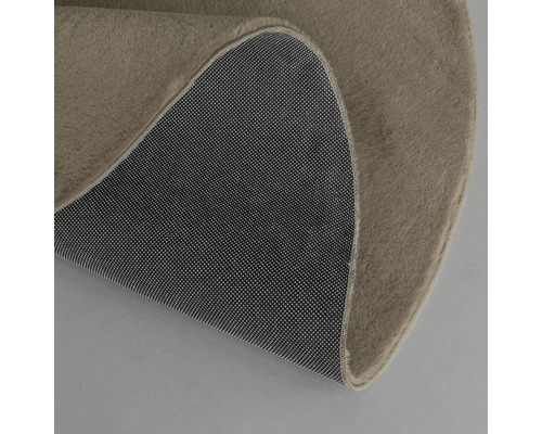 Vue détaillée d''un tapis rond avec surface textile et dessous antidérapant