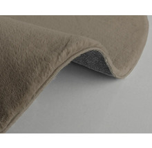 Vue détaillée d''un tapis beige avec une surface douce et un envers tissé