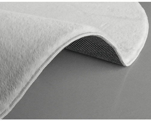 Vue détaillée d''un tapis blanc à poils et envers textile