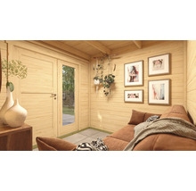 Intérieur d'une cabane de jardin avec canapé, tableaux au mur et plantes décoratives