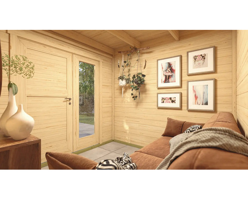 Intérieur d'une cabane de jardin avec canapé, tableaux au mur et plantes décoratives