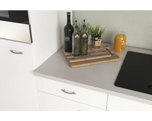 Plan de travail de cuisine avec planches à découper, herbes aromatiques, bouteilles d''huile et boisson