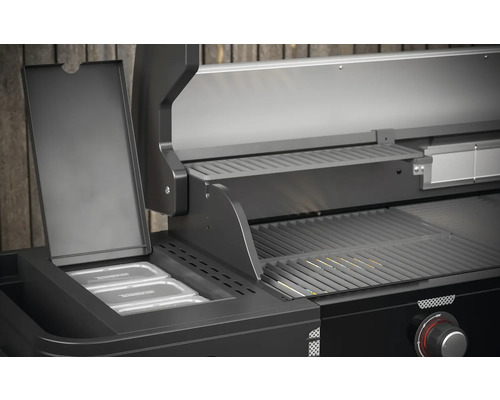 Vue détaillée d''un barbecue à gaz noir avec grille de maintien au chaud et récipients
